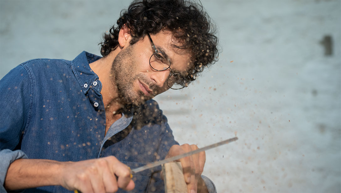 Man doing woodworking with glasses on